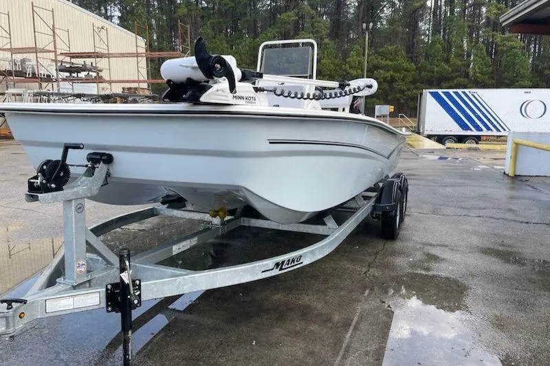 Slide: The Image of 2024 Mako Pro Skiff 19 CC boat on trailer in outdoor setting. - 10