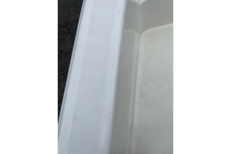 Slide: The Image of Close-up of 2024 Mako Pro Skiff 19 CC boat's textured white surface. - 5