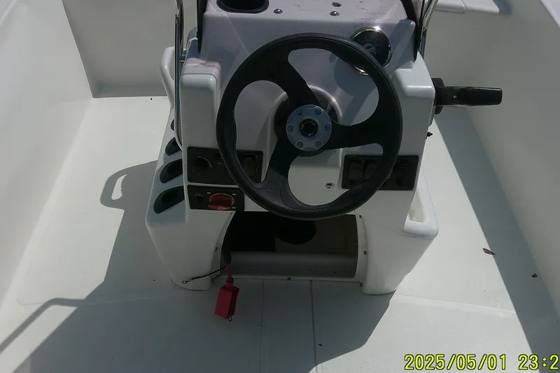 Slide: The Image of 2024 Mako Pro Skiff 17 CC boat console with steering wheel and controls. - 5