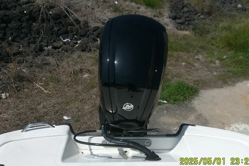 Slide: The Image of 2024 Mako Pro Skiff 17 CC boat with black outboard motor, grassy background. - 6