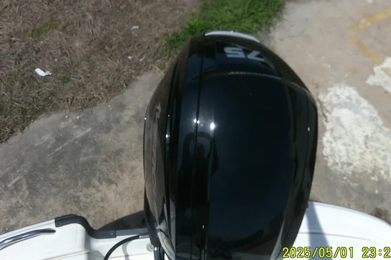 Slide: The Image of 2024 Mako Pro Skiff 17 CC boat engine, top view, on concrete and grass background. - 8