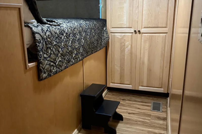 Slide: The Image of Interior of 2002 Navigator houseboat with wooden cabinets and patterned bedding. - 18