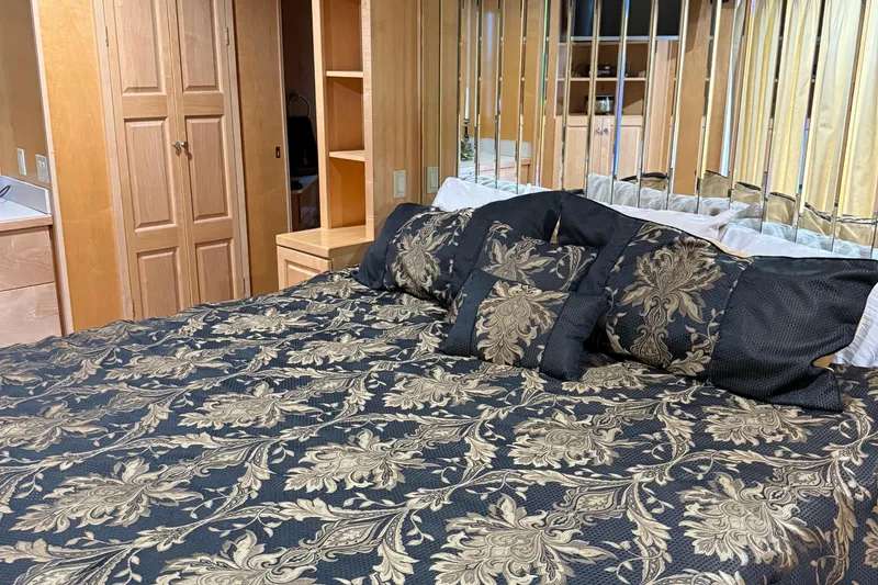 Slide: The Image of Luxurious bedroom interior on a 2002 Navigator houseboat with elegant bedding and wooden cabinetry. - 4