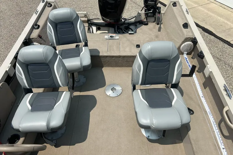 Slide: The Image of 2003 Crestliner 1850 Fish Hawk SC interior with four gray seats and motor. - 15