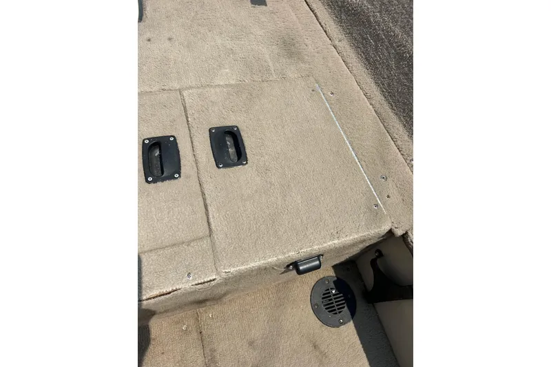 Slide: The Image of 2003 Crestliner 1850 Fish Hawk SC boat interior with storage compartments and carpeted flooring. - 26