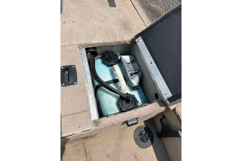 Slide: The Image of Storage compartment in 2003 Crestliner 1850 Fish Hawk SC boat, containing fuel and oil containers. - 27