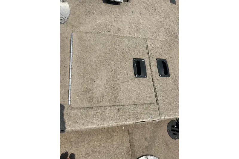 Slide: The Image of 2003 Crestliner 1850 Fish Hawk SC boat deck with storage compartments and carpeted surface. - 28