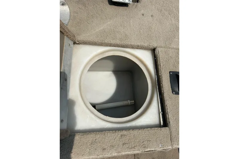 Slide: The Image of 2003 Crestliner 1850 Fish Hawk SC livewell compartment with beige carpeted interior. - 29