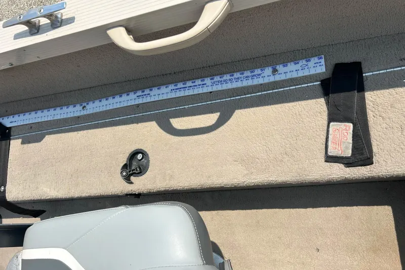 Slide: The Image of 2003 Crestliner 1850 Fish Hawk SC interior with measuring tape and rod holder. - 40