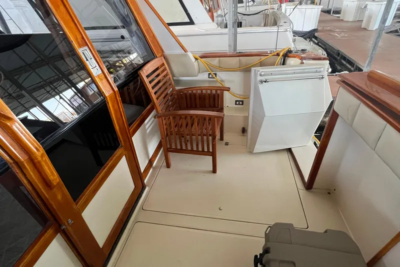 Slide: The Image of 1986 Bayliner 4550 Motoryacht deck with wooden chair and storage compartment. - 10