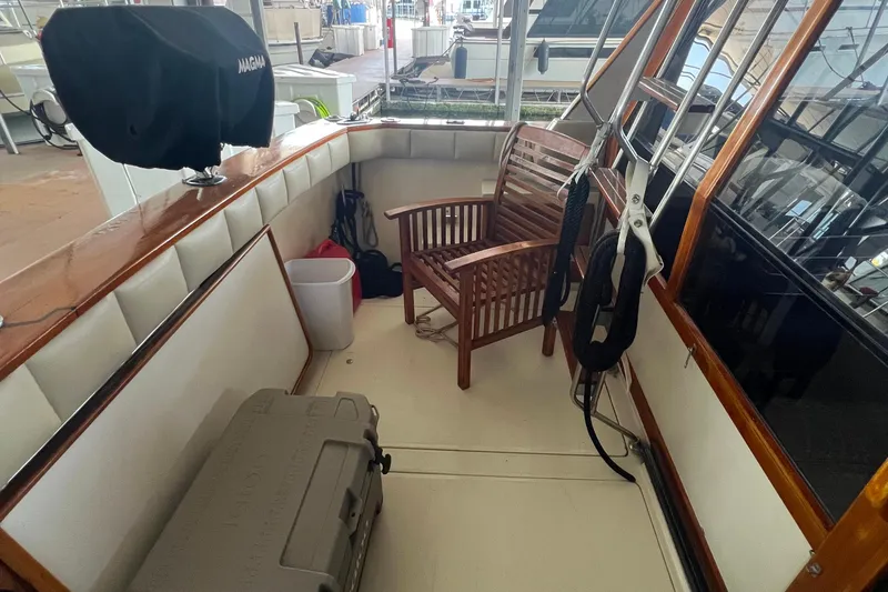 Slide: The Image of 1986 Bayliner 4550 Motoryacht deck with wooden chair, cooler, and grill. - 11