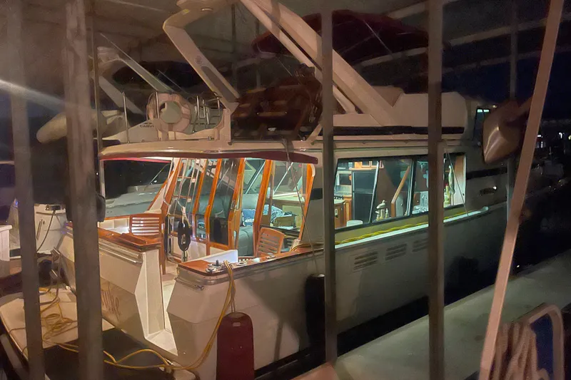 Slide: The Image of 1986 Bayliner 4550 Motoryacht docked at night, illuminated interior visible. - 12