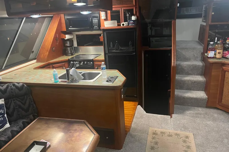 Slide: The Image of Interior of 1986 Bayliner 4550 Motoryacht with kitchen, stairs, and seating area. - 13