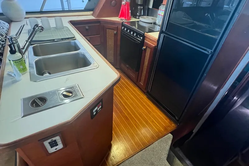 Slide: The Image of 1986 Bayliner 4550 Motoryacht kitchen with dual sinks, stove, and refrigerator. - 14