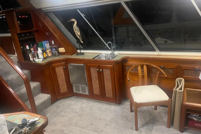 Slide: The Image of Luxurious interior of 1986 Bayliner 4550 Motoryacht with bar, sink, and wooden chair. - 18