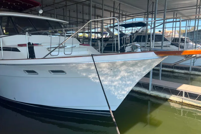 Slide: The Image of 1986 Bayliner 4550 Motoryacht docked in a marina, side view. - 2