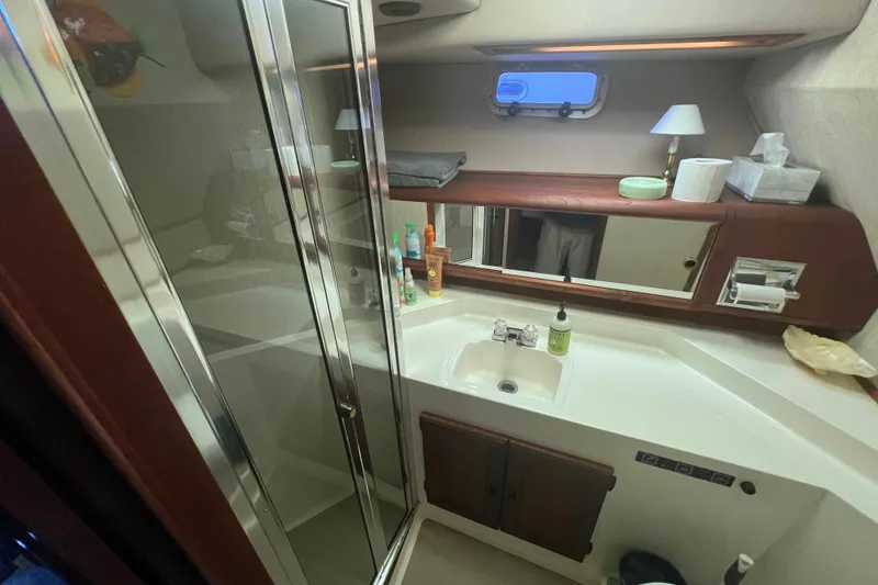 Slide: The Image of Bathroom interior of 1986 Bayliner 4550 Motoryacht with sink, mirror, and toiletries. - 22
