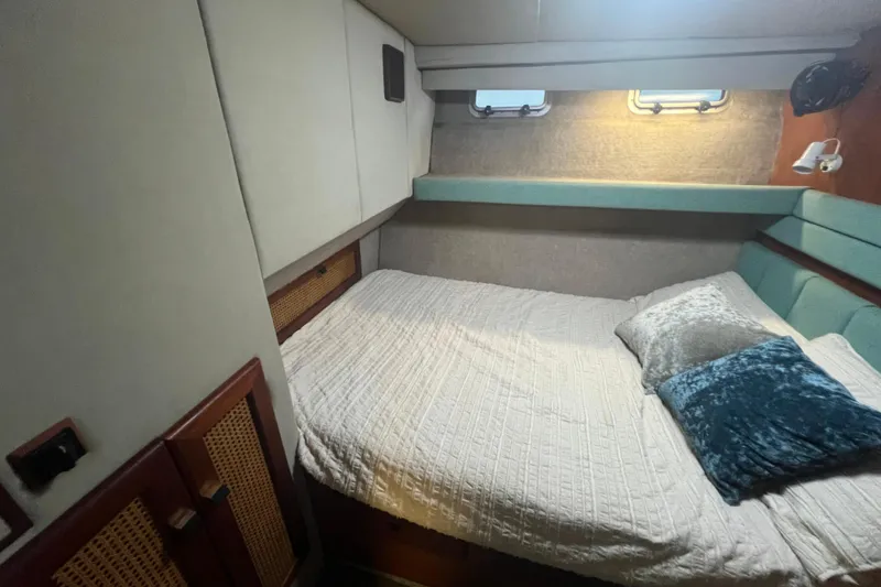 Slide: The Image of Cozy bedroom interior of 1986 Bayliner 4550 Motoryacht with plush bedding and soft lighting. - 26