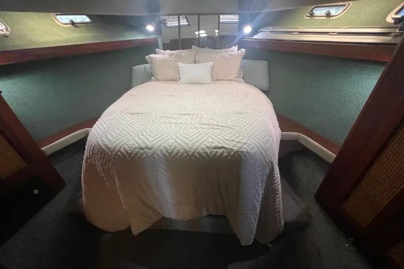 Slide: The Image of Cozy bedroom in 1986 Bayliner 4550 Motoryacht with elegant bedding and ambient lighting. - 32