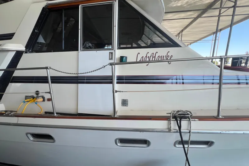 Slide: The Image of 1986 Bayliner 4550 Motoryacht "LadyHawke" docked under a canopy. - 4