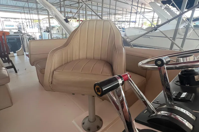Slide: The Image of 1986 Bayliner 4550 Motoryacht helm with beige captain's chair and steering controls. - 46