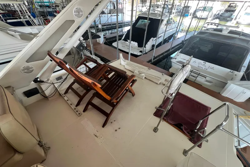 Slide: The Image of 1986 Bayliner 4550 Motoryacht deck with wooden chair and marina view. - 50