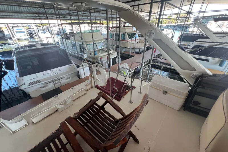 Slide: The Image of 1986 Bayliner 4550 Motoryacht docked in marina, featuring spacious deck and seating area. - 51