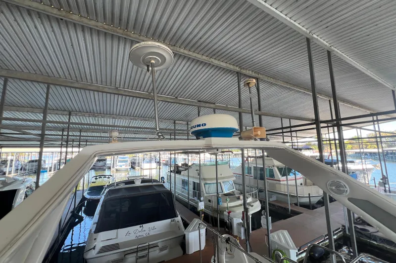 Slide: The Image of 1986 Bayliner 4550 Motoryacht docked in a covered marina with other boats. - 53