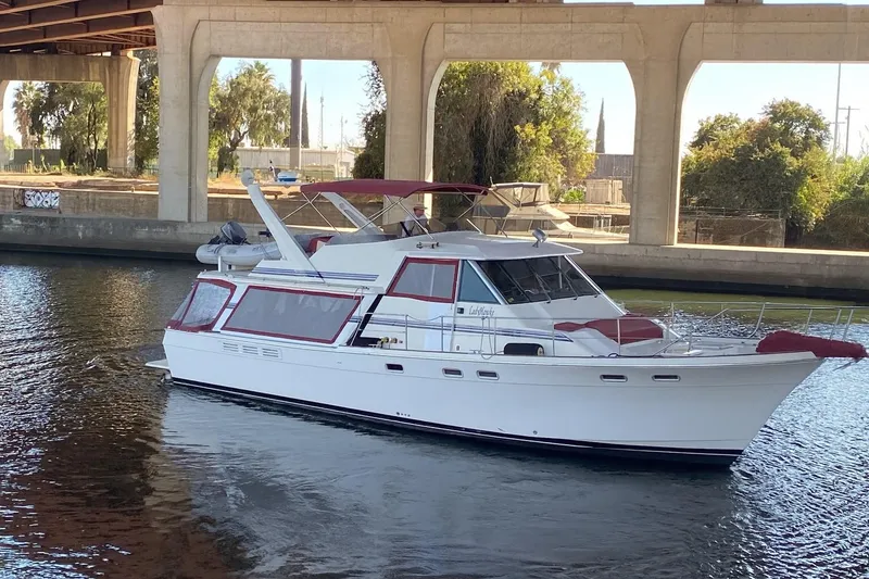 Slide: The Image of 1986 Bayliner 4550 Motoryacht cruising under a bridge on a sunny day. - 68