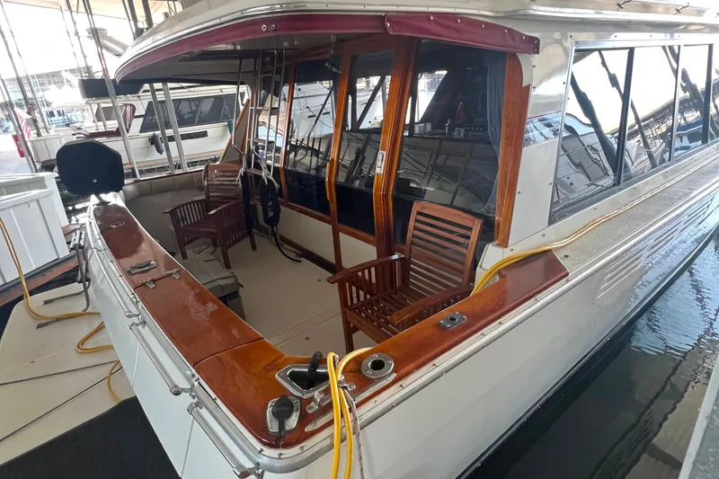 Slide: The Image of 1986 Bayliner 4550 Motoryacht with wooden deck chairs and polished wood accents in marina. - 9