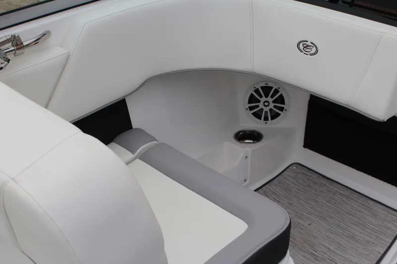 Slide: The Image of 2024 Cobalt 220S boat interior with white seating, speaker, and cup holder. - 16