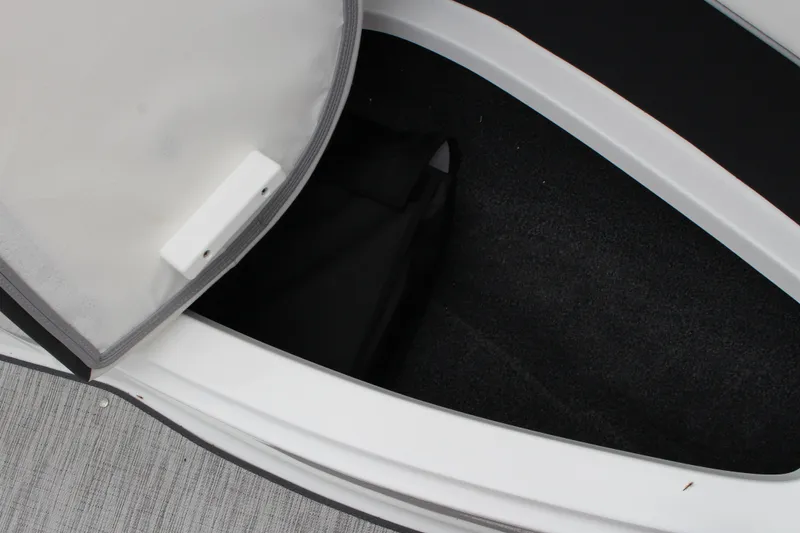 Slide: The Image of Open storage compartment in 2024 Cobalt 220S boat, featuring carpeted interior. - 19