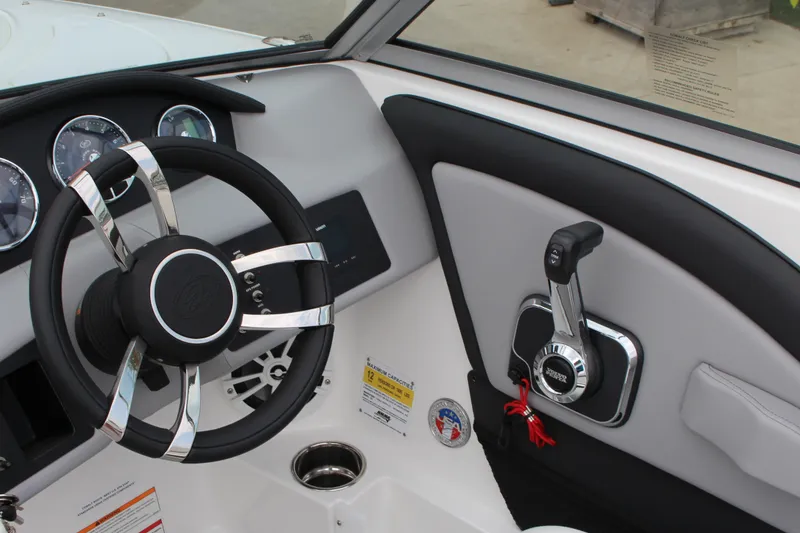 Slide: The Image of 2024 Cobalt 220S boat dashboard with steering wheel and control lever. - 23