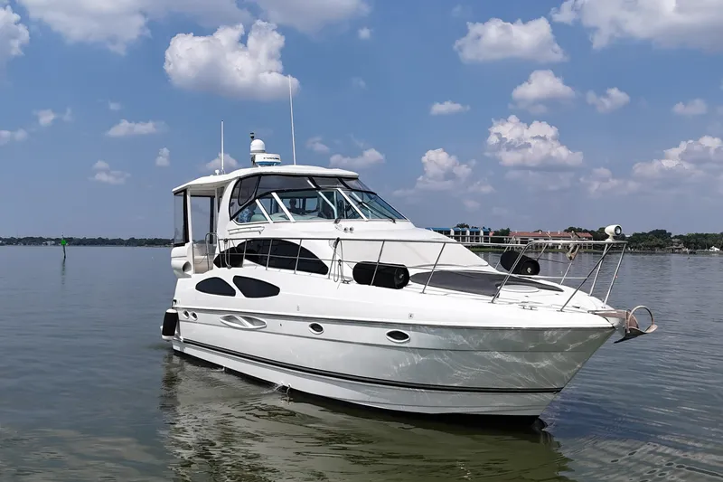 Slide: The Image of 2004 Cruisers Yachts 405 Express Motoryacht on calm water under a blue sky. - 14