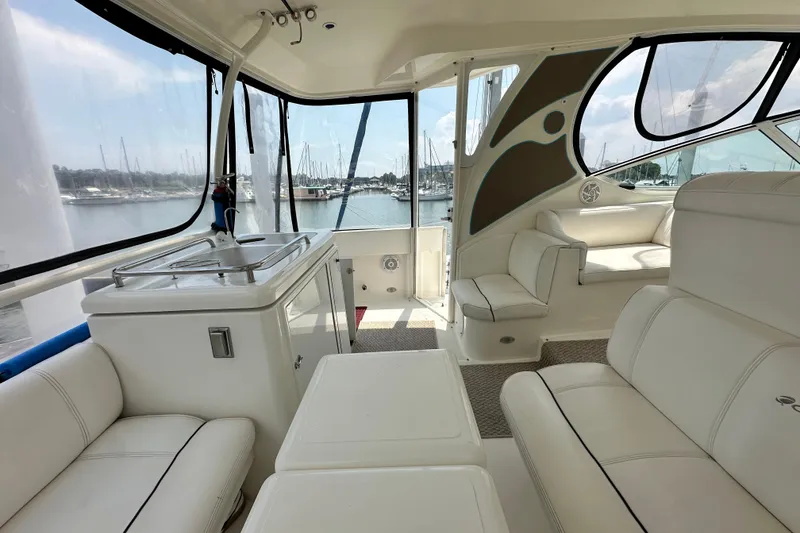 Slide: The Image of 2004 Cruisers Yachts 405 Express Motoryacht interior with white seating and marina view. - 26