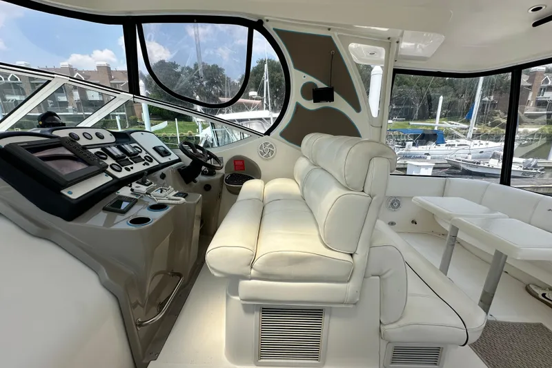 Slide: The Image of 2004 Cruisers Yachts 405 Express Motoryacht helm with white leather seating and control panel. - 30