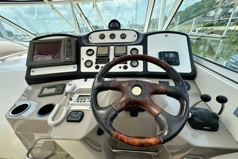Slide: The Image of 2004 Cruisers Yachts 405 Express Motoryacht helm with steering wheel and navigation controls. - 34