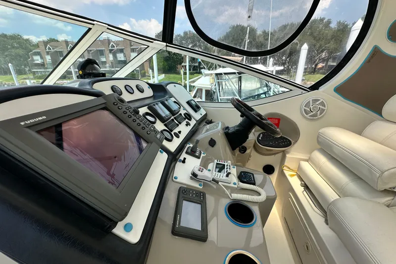 Slide: The Image of 2004 Cruisers Yachts 405 Express Motoryacht helm with navigation equipment and plush seating. - 37