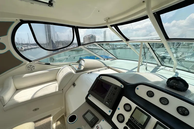 Slide: The Image of 2004 Cruisers Yachts 405 Express Motoryacht helm with marina view, featuring navigation instruments. - 40