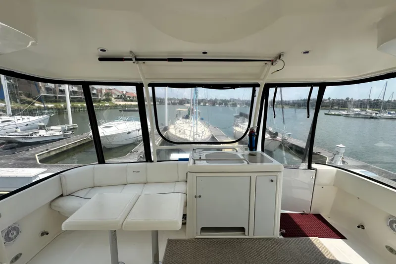 Slide: The Image of Interior view of 2004 Cruisers Yachts 405 Express Motoryacht, featuring seating and marina backdrop. - 41