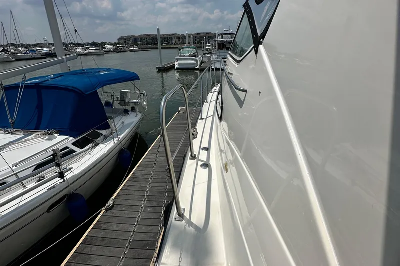 Slide: The Image of 2004 Cruisers Yachts 405 Express Motoryacht docked beside sailboat in marina. - 43