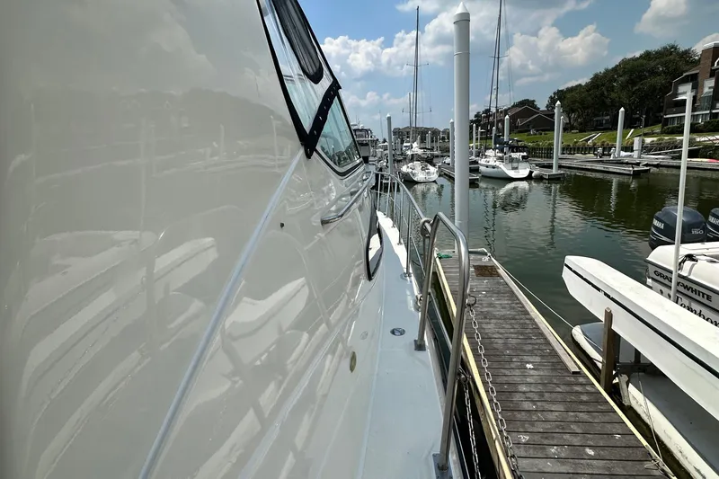 Slide: The Image of 2004 Cruisers Yachts 405 Express Motoryacht docked at a marina under a blue sky. - 44