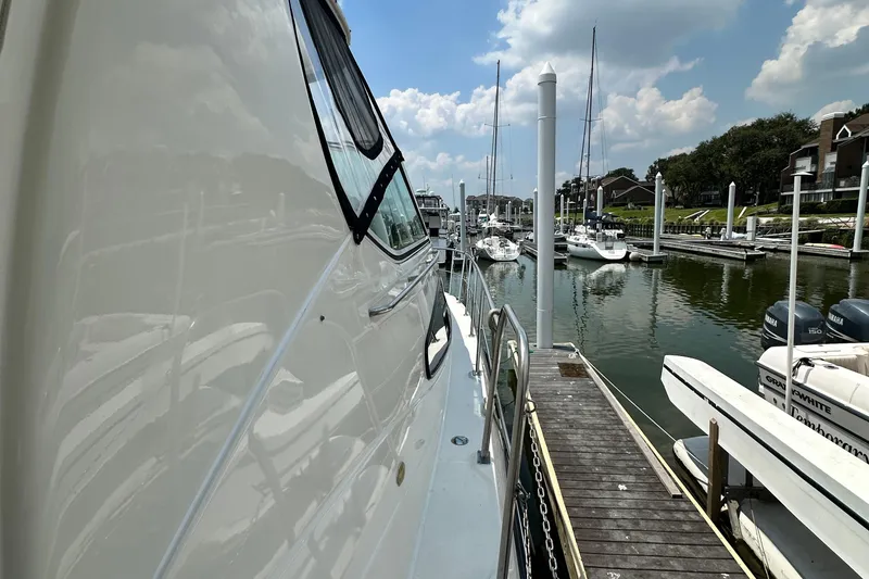 Slide: The Image of 2004 Cruisers Yachts 405 Express Motoryacht docked at marina under blue sky. - 45