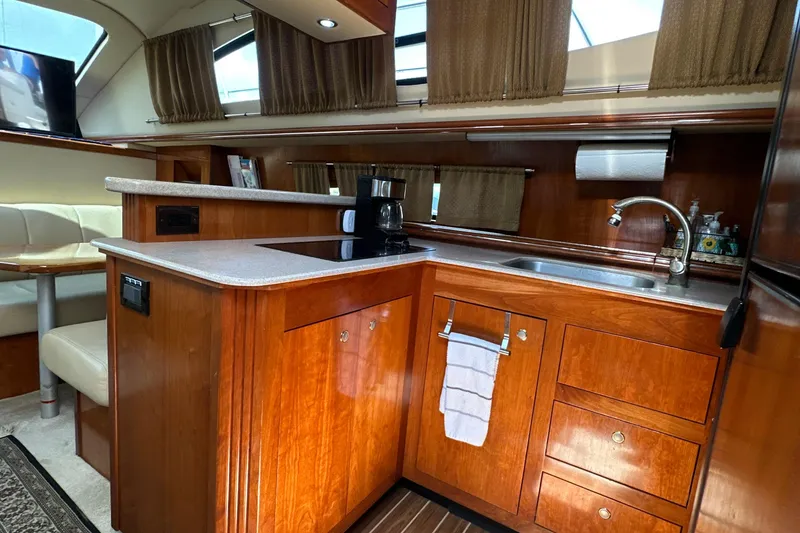 Slide: The Image of Luxurious 2004 Cruisers Yachts 405 Express Motoryacht kitchen with wood cabinetry and modern amenities. - 54