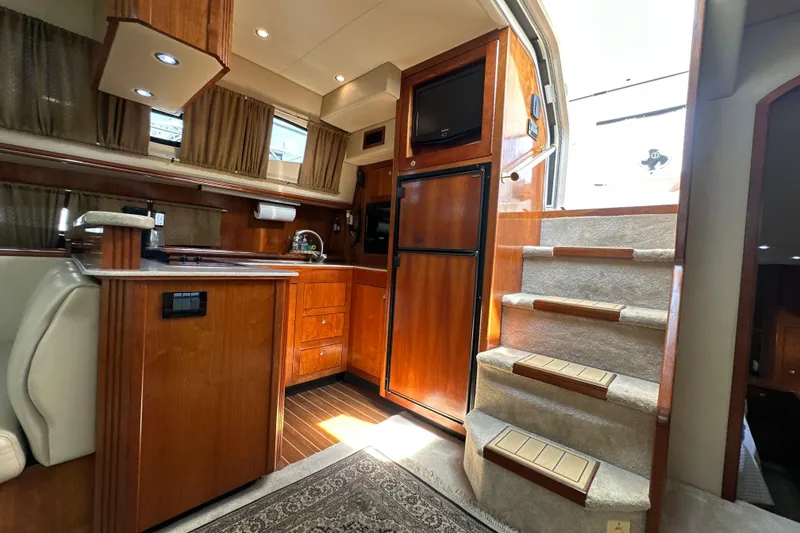 Slide: The Image of Luxurious interior of 2004 Cruisers Yachts 405 Express Motoryacht with wooden cabinetry and carpeted stairs. - 55