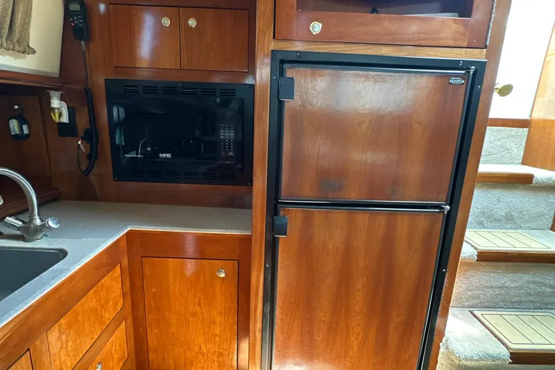 Slide: The Image of 2004 Cruisers Yachts 405 Express Motoryacht kitchen with wood cabinetry and appliances. - 57