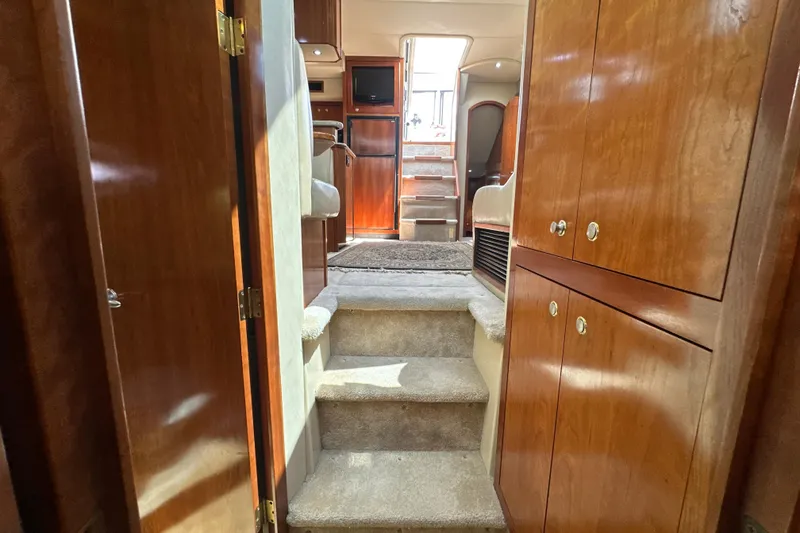 Slide: The Image of Interior of 2004 Cruisers Yachts 405 Express Motoryacht with wooden cabinetry and carpeted stairs. - 79