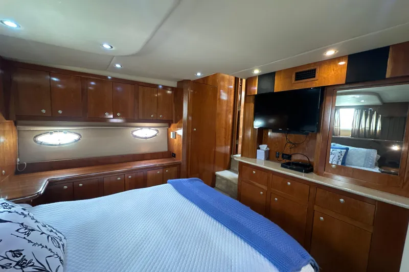 Slide: The Image of Luxurious 2004 Cruisers Yachts 405 Express Motoryacht bedroom with wood cabinetry and modern amenities. - 89