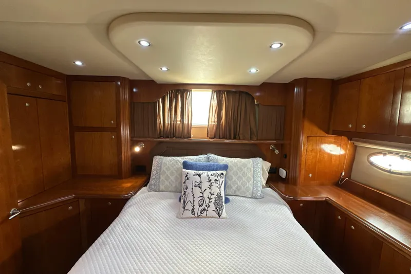 Slide: The Image of Luxurious 2004 Cruisers Yachts 405 Express Motoryacht bedroom with elegant wood cabinetry. - 90