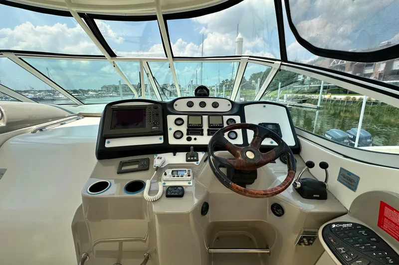 Slide: The Image of 2004 Cruisers Yachts 405 Express Motoryacht helm with steering wheel and navigation controls. - 33